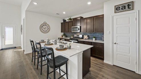 kitchen with large island with white counters and brown cabinets