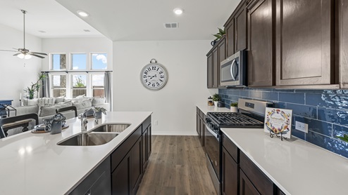 kitchen with brown cabinets white counters and blue blacksplash