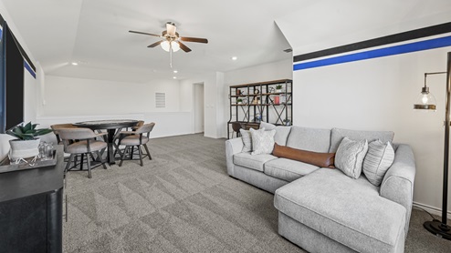 upstairs media room with furniture and ceiling fan