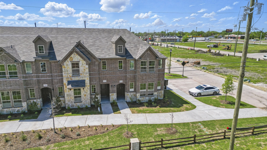 exterior of townhome with brick exterior and large windows facing the front
