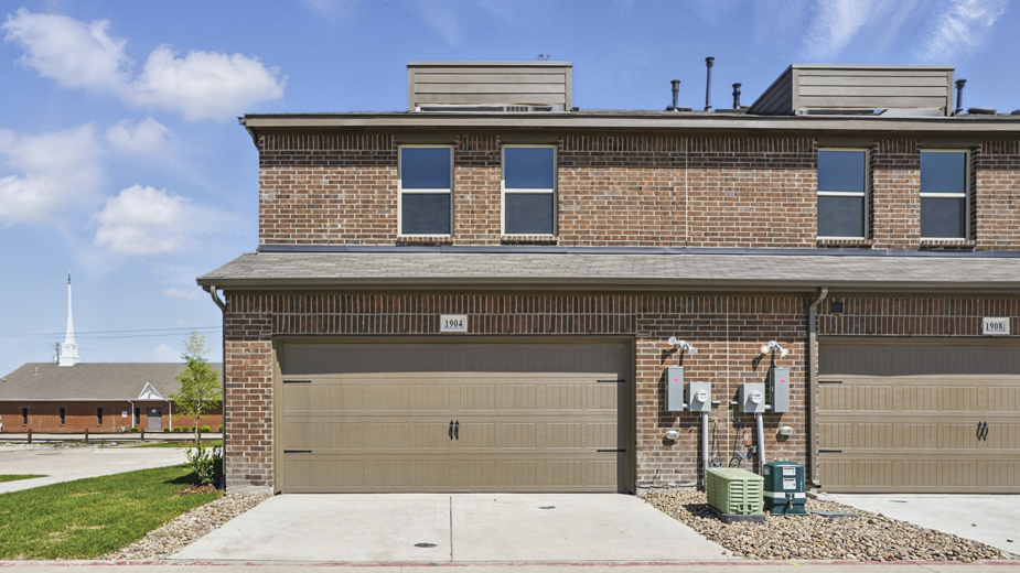exterior of the back of the townhome with garage entry
