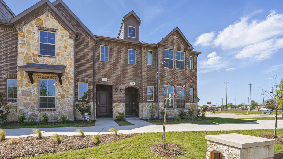 exterior of townhome with brick exterior and large windows facing the front
