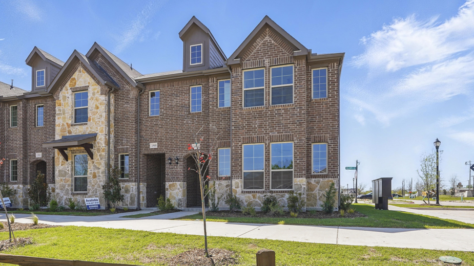 exterior of townhome with brick exterior and large windows facing the front