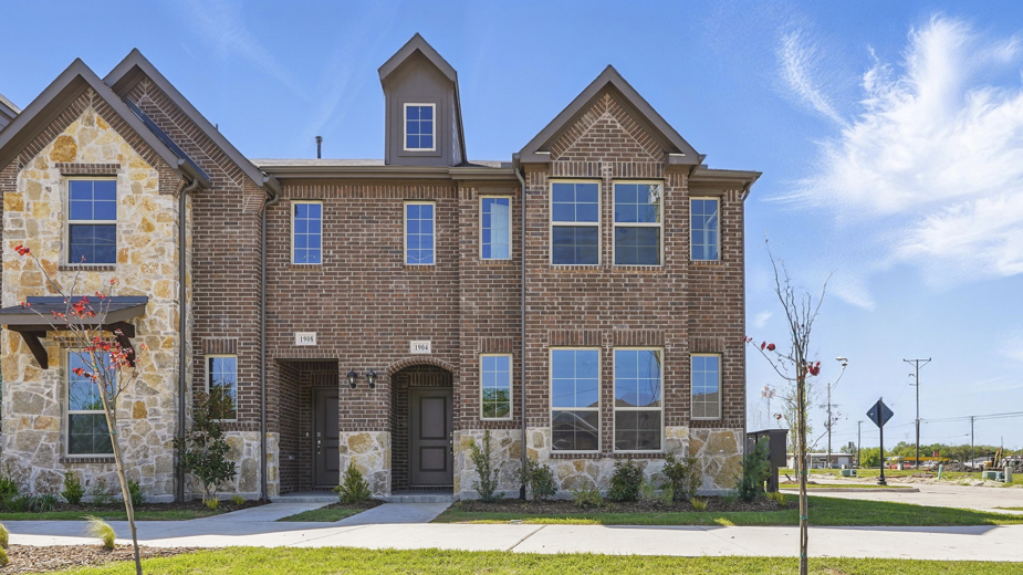 exterior of townhome with brick exterior and large windows facing the front