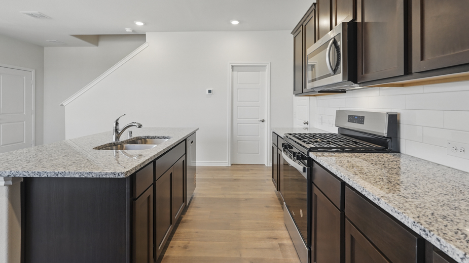 kitchen area with hardwood floors light colored counters dark cabinets and kitchen island