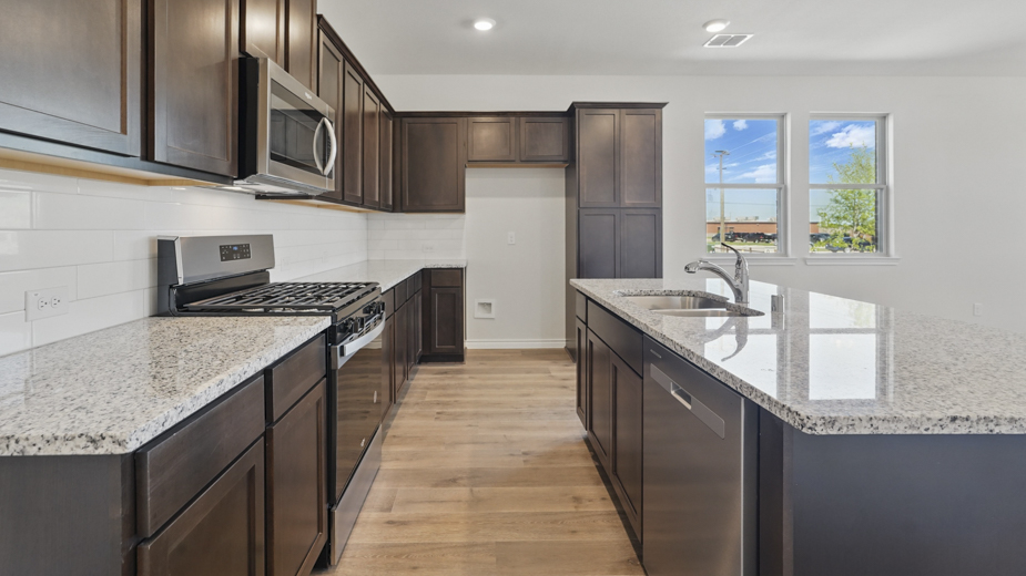 kitchen area with hardwood floors light colored counters dark cabinets and kitchen island