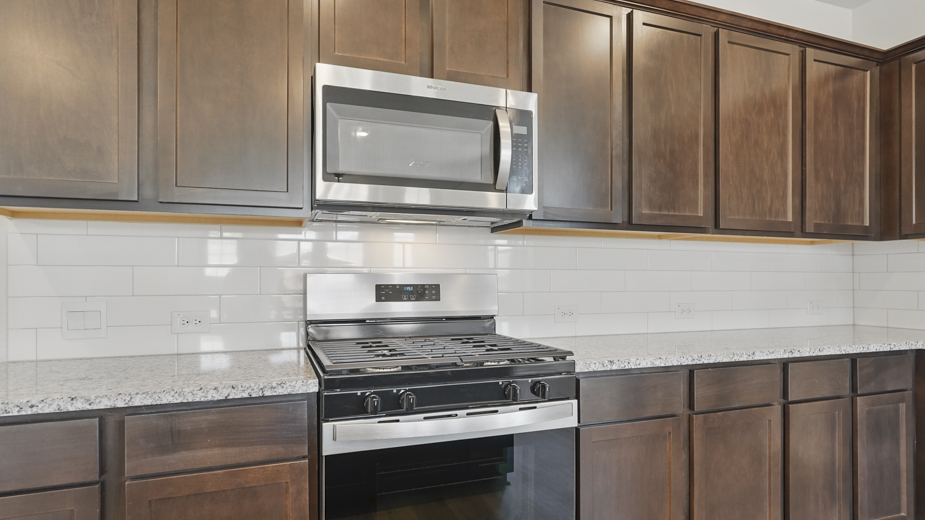 kitchen area with hardwood floors light colored counters dark cabinets and kitchen island