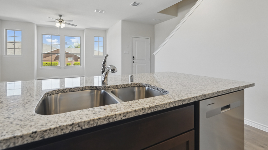 kitchen area with hardwood floors light colored counters dark cabinets and kitchen island