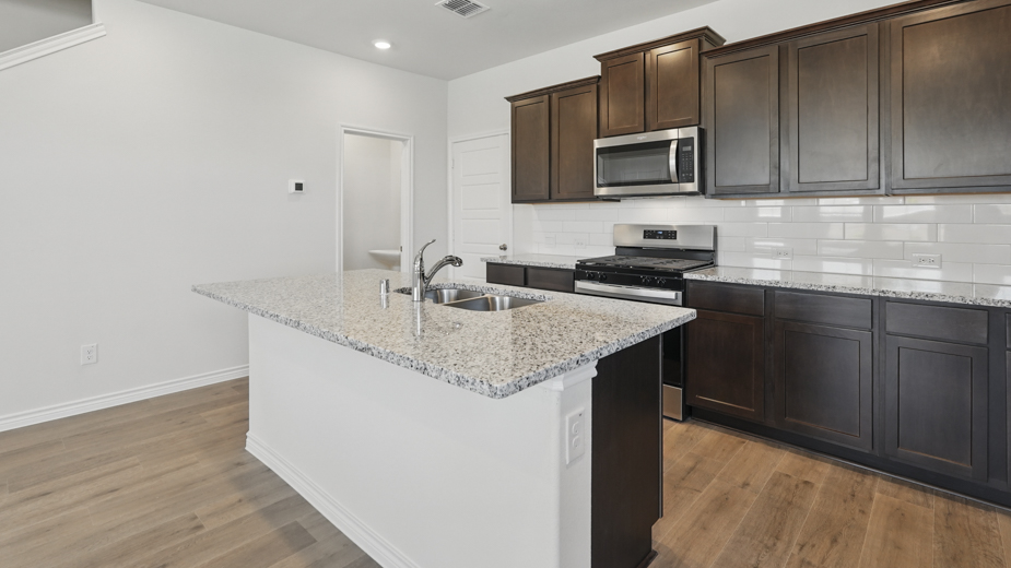 kitchen area with hardwood floors light colored counters dark cabinets and kitchen island