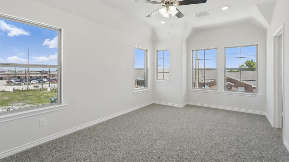 primary bedroom with grey carpet large windows providing natural light and white walls
