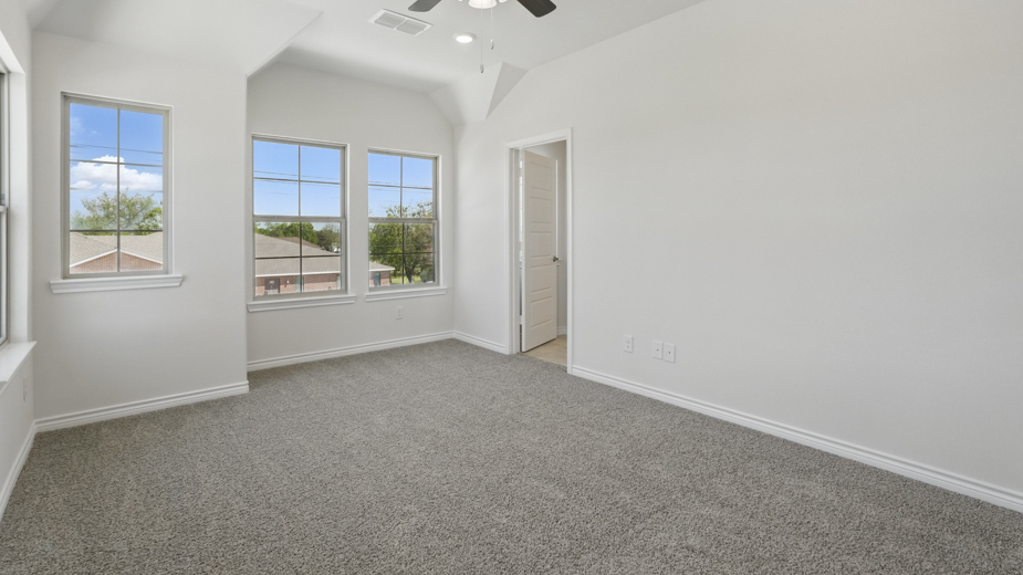 primary bedroom with grey carpet large windows providing natural light and white walls