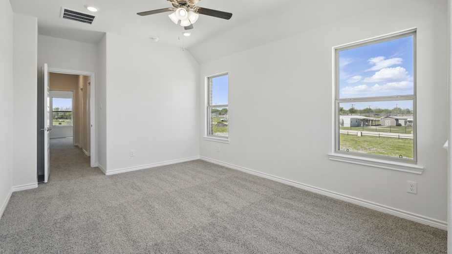 primary bedroom with grey carpet large windows providing natural light and white walls