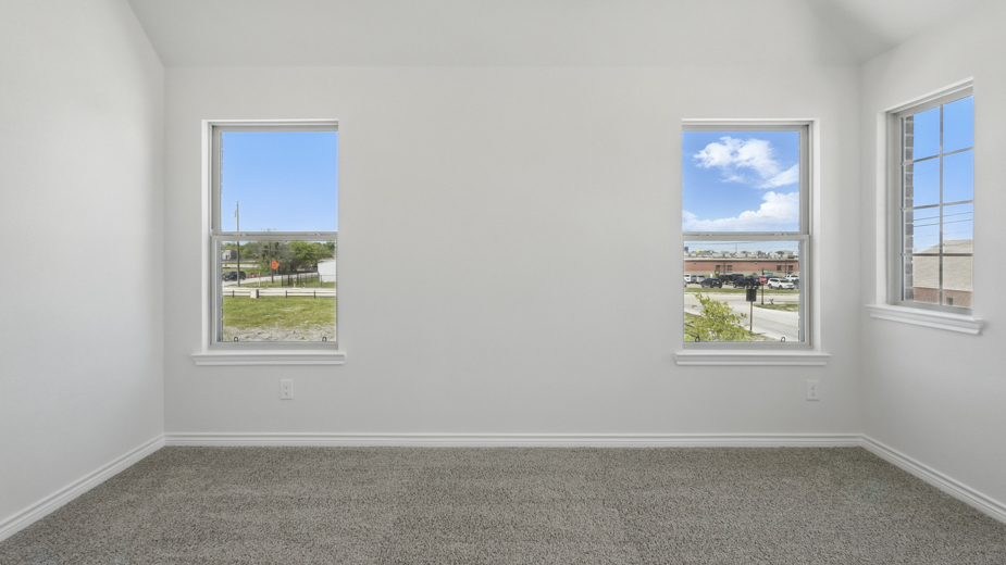 primary bedroom with grey carpet large windows providing natural light and white walls