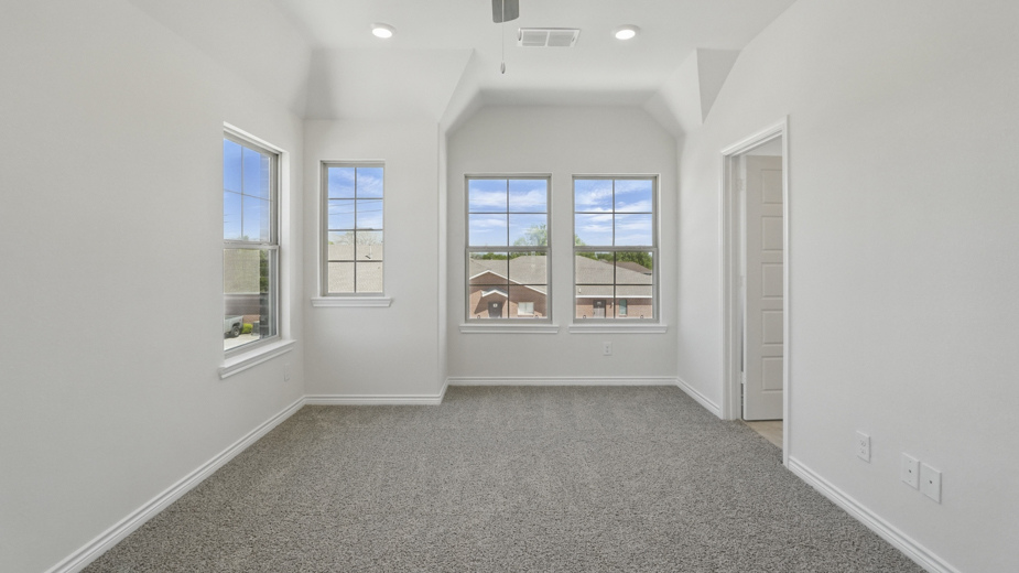 primary bedroom with grey carpet large windows providing natural light and white walls