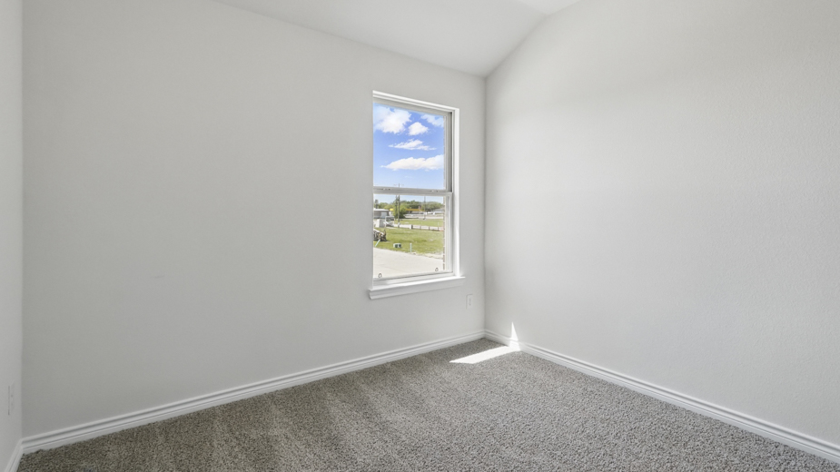 secondary bedroom with light colored carpet white walls and natural light coming from large window