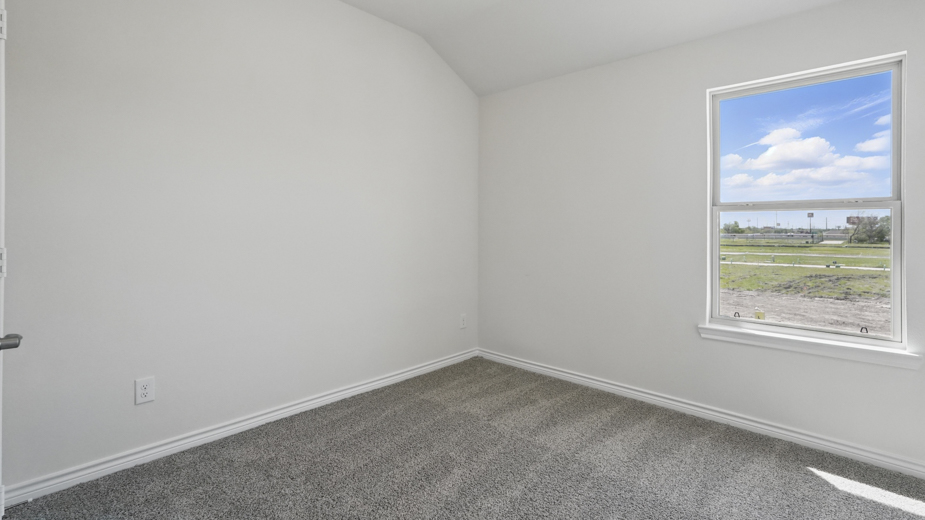 secondary bedroom with light colored carpet white walls and natural light coming from large window