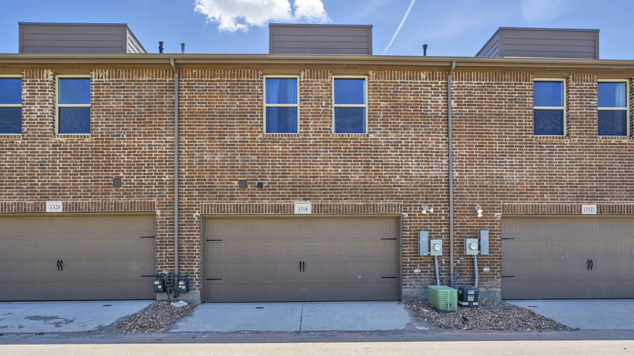 back of the townhome with large windows and garage entry