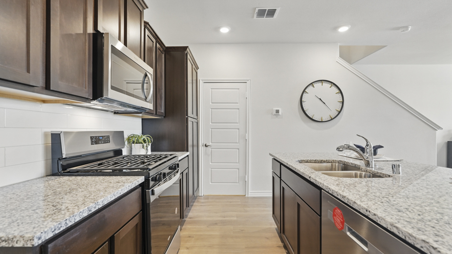 kitchen area with hardwood floors dark cabinets and light colored counters