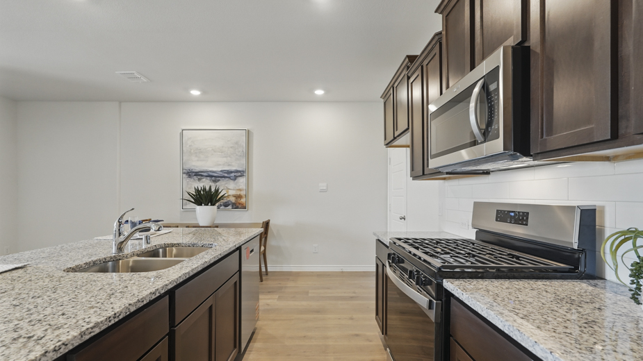 kitchen area with hardwood floors dark cabinets and light colored counters