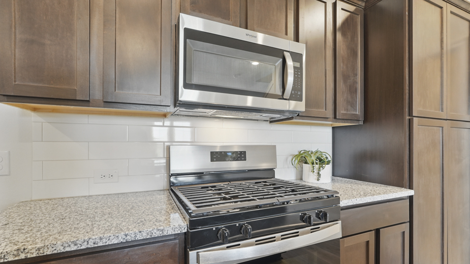 kitchen area with hardwood floors dark cabinets and light colored counters