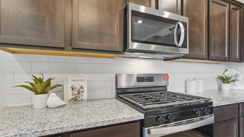 kitchen area with hardwood floors dark cabinets and white counters