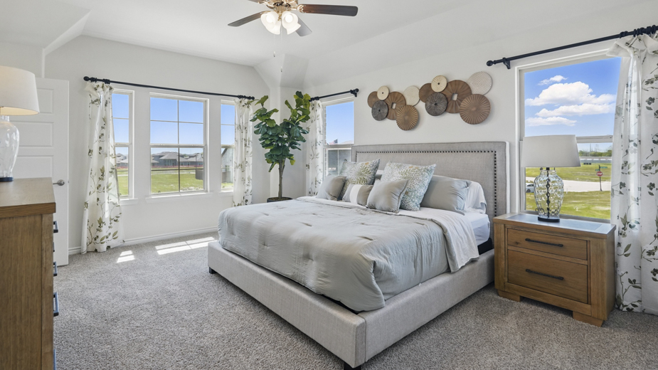 primary bedroom with carpet and large windows providing natural light