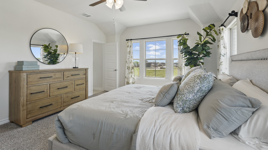 primary bedroom with carpet and large windows providing natural light