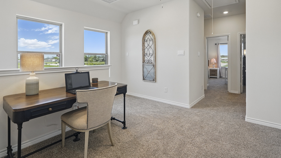 upstairs loft area with carpet and large windows providing natural light