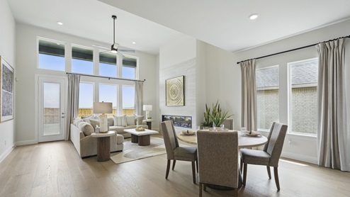 Interior dining area with large windows looking into living room