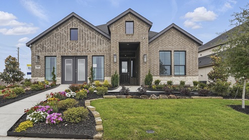Exterior of one story brick home with two car garage model home