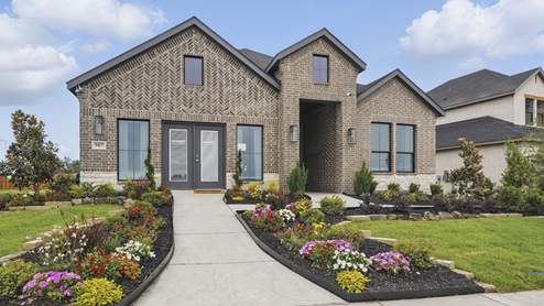 Exterior of one story brick home with two car garage model home