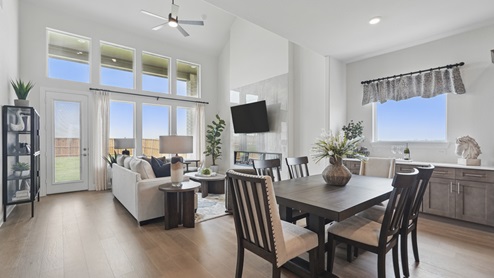 Interior dining area with large windows looking into living room