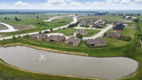 Exterior sky view of the whole community with a pond