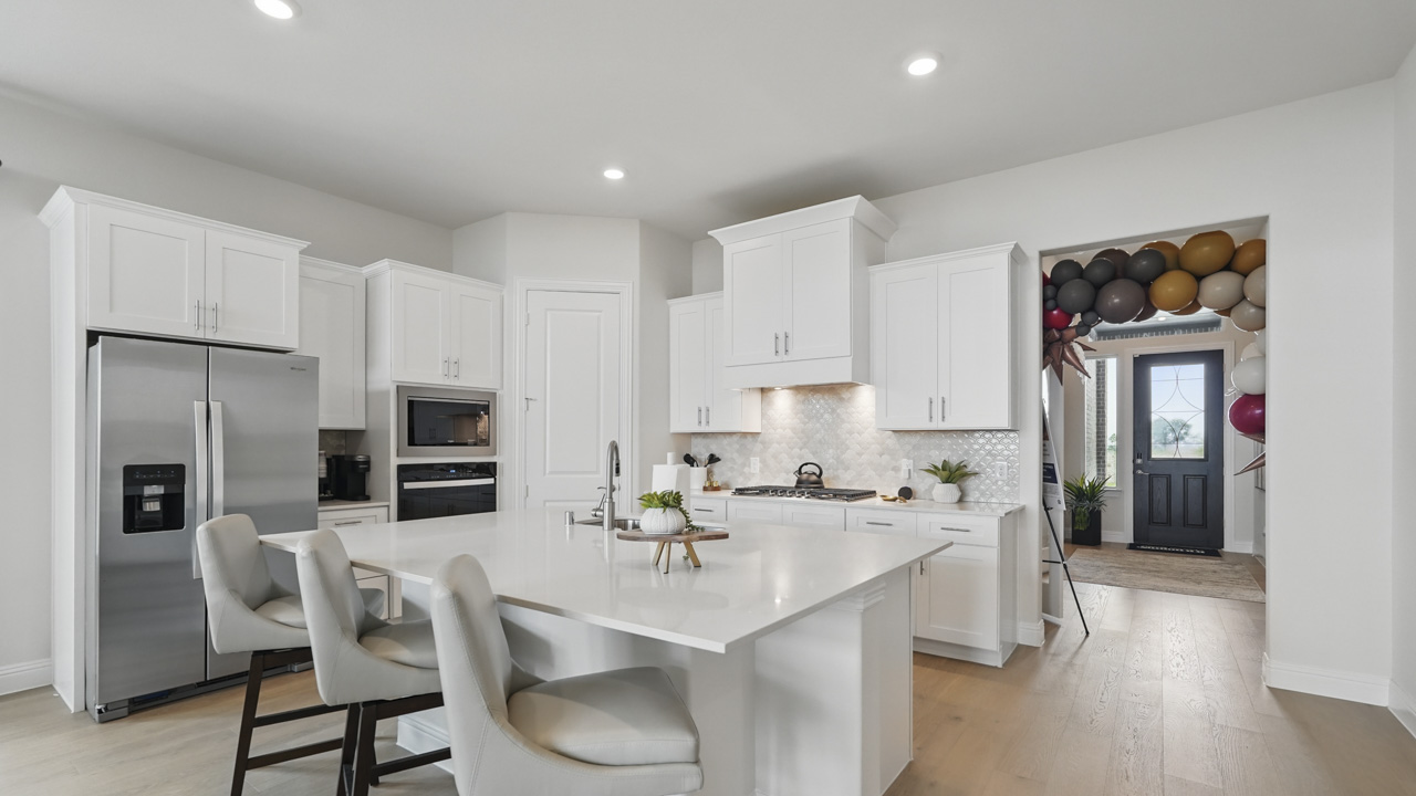 kitchen area with hardwood floors and white cabinets