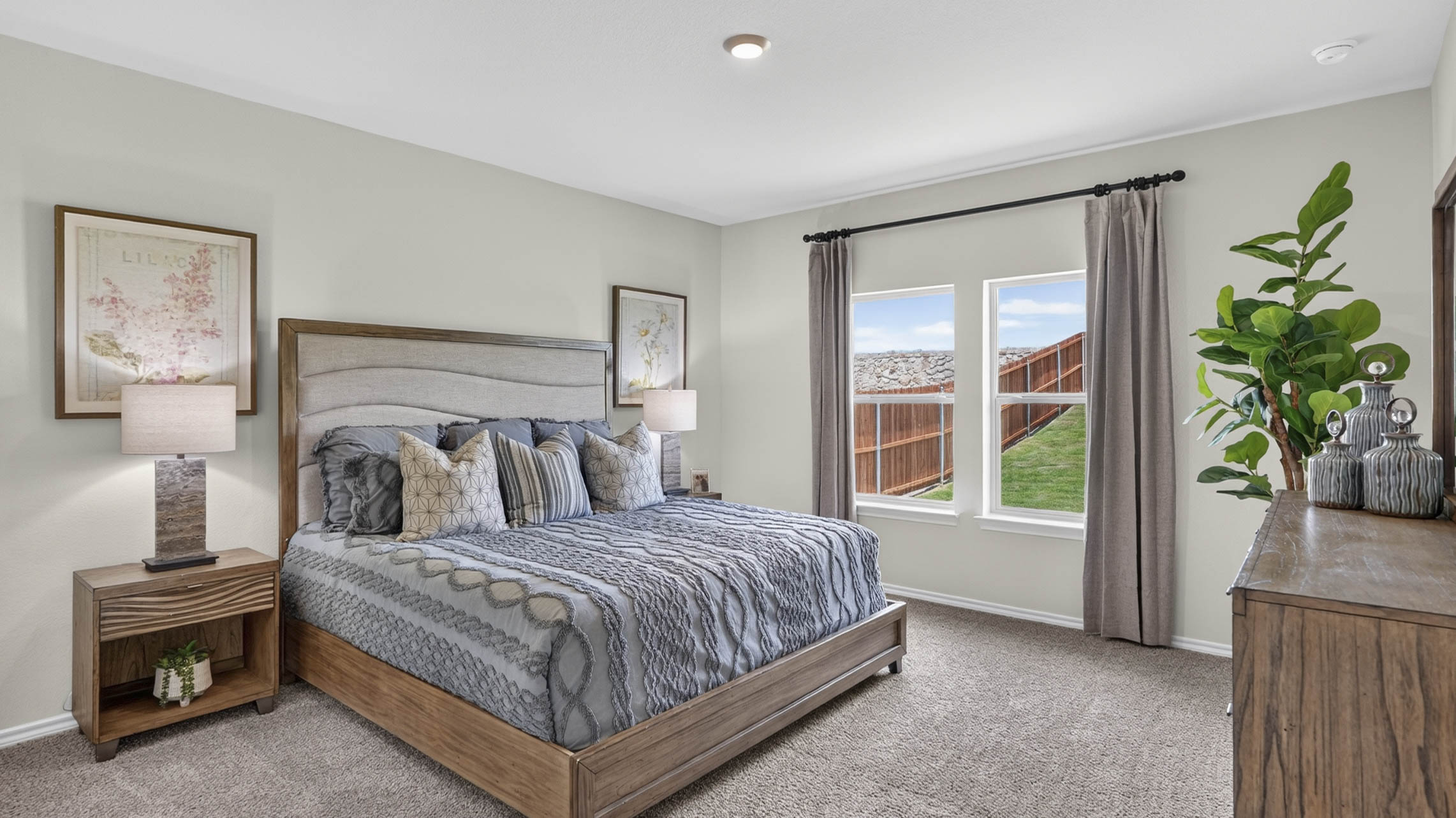 primary bedroom with large windows facing the backyard providing natural light