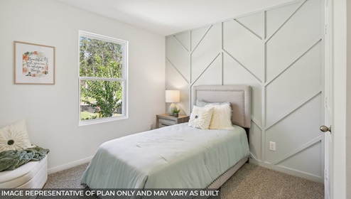Cottage series one story home bedroom with bed and accent wall