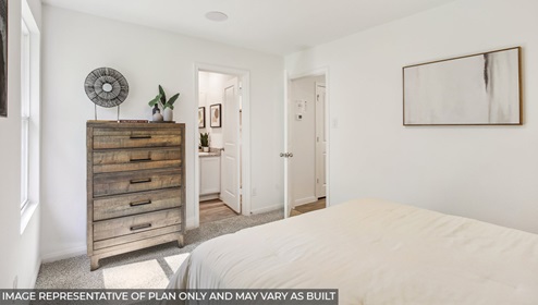Cottage series one story home primary bedroom with bed and dresser
