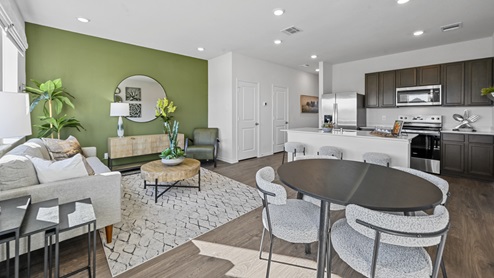 V19 Plan Interior of kitchen and living room area with kitchen island and windows with green accent wall
