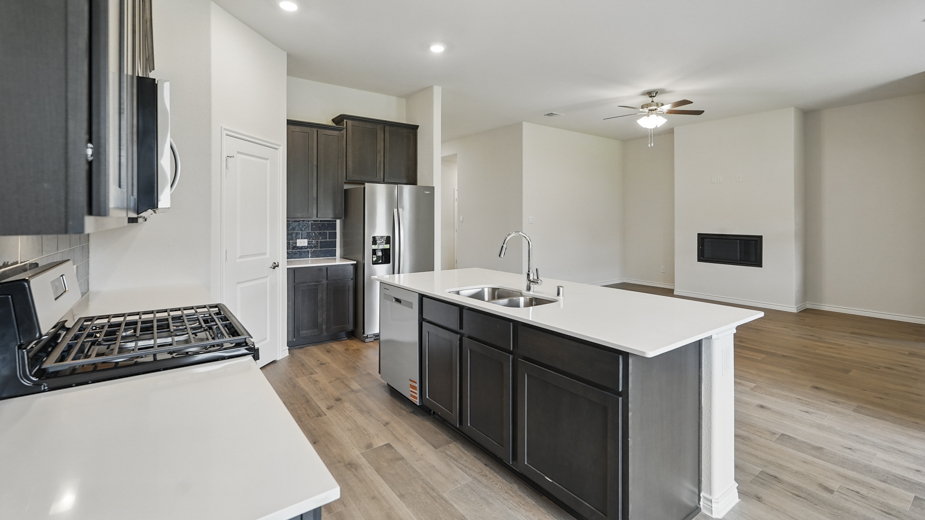 Open concept kitchen with large island with white quartz countertops.
