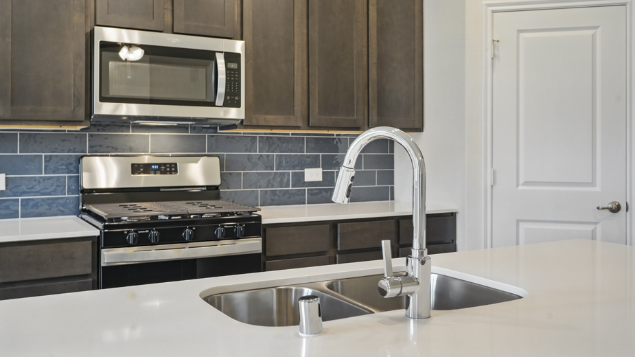 Kitchen with blue tile backsplash.