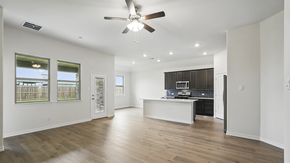 Living room with wood like tile flooring and windows.