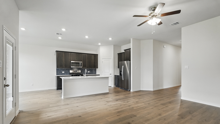 Living room with wood like tile flooring and windows.