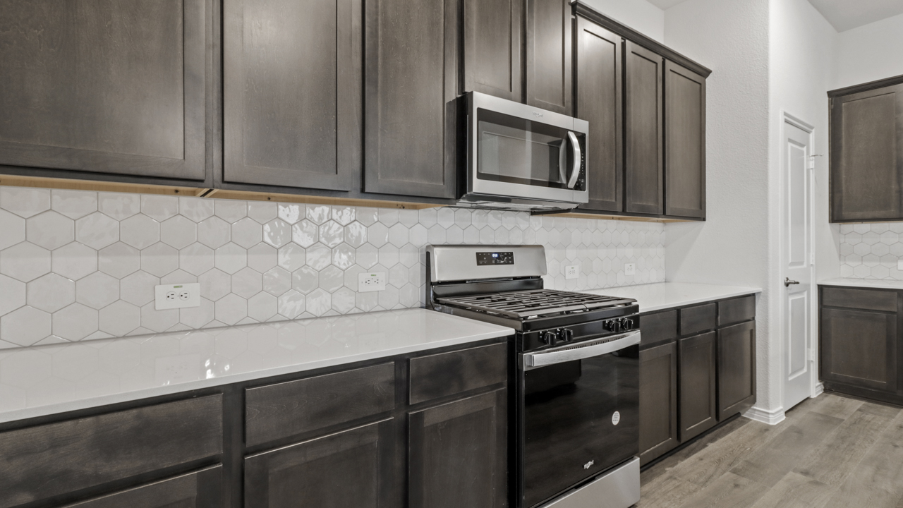 elongated countertops with brown cabinets and stainless steel appliances