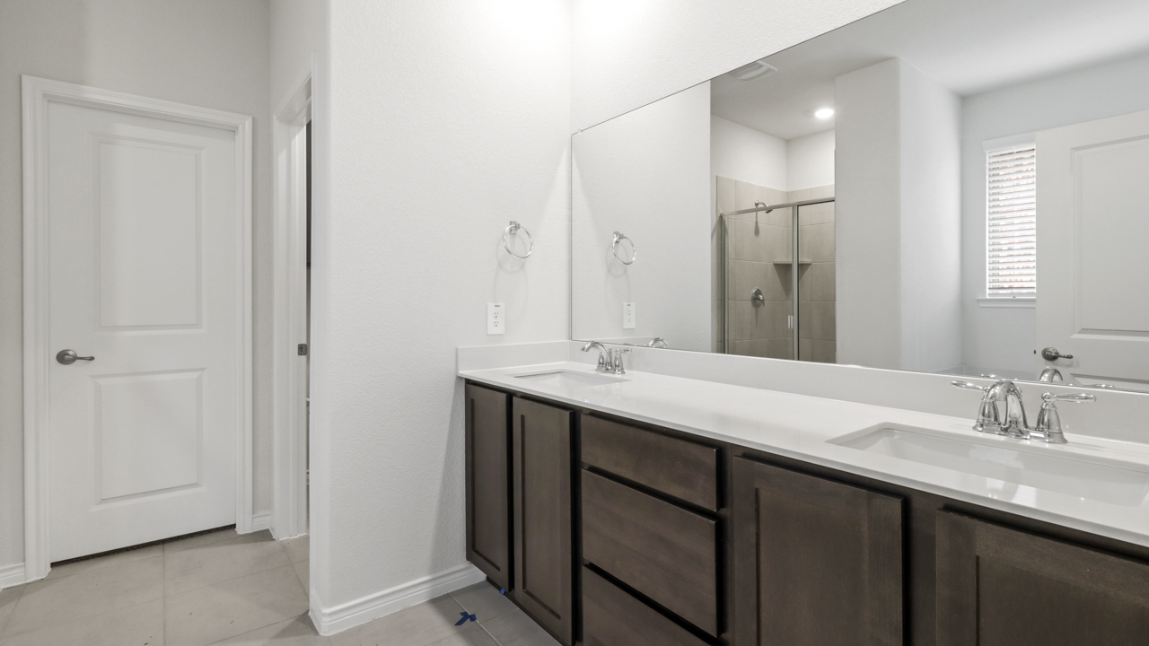 primary bathroom with large vanity and brown cabinets
