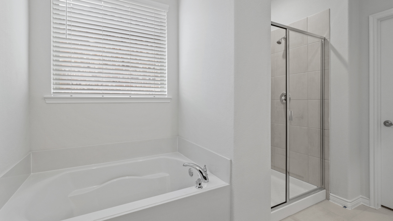 primary bathroom with walk in shower and garden tub