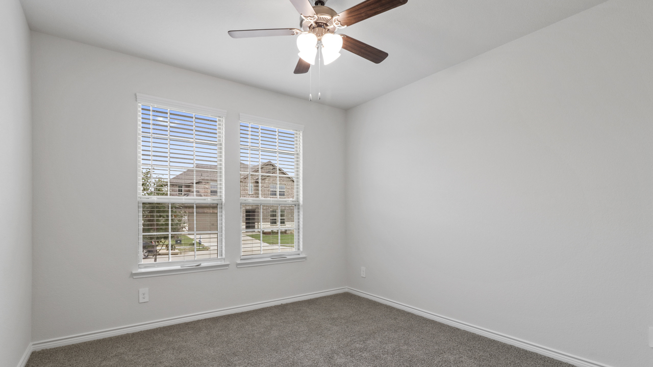 bedroom with large window and ceiling fan