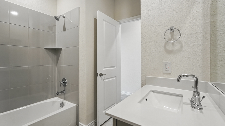 bathroom with tub and single sink vanity