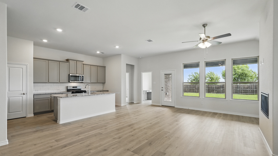 Living room with windows and kitchen with brown cabinets