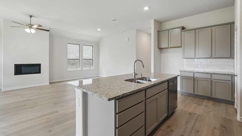 Living room with windows and kitchen with brown cabinets