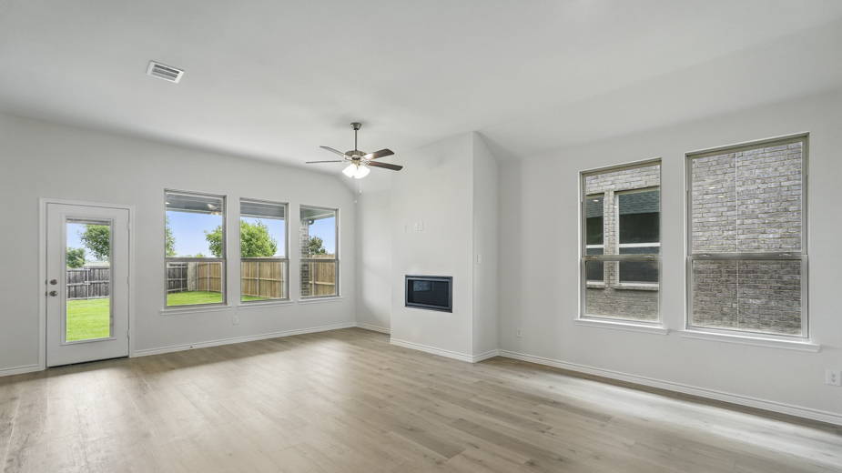 Living room with windows and kitchen with brown cabinets